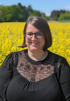 Eine Frau vor einem blühenden Rapsfeld
